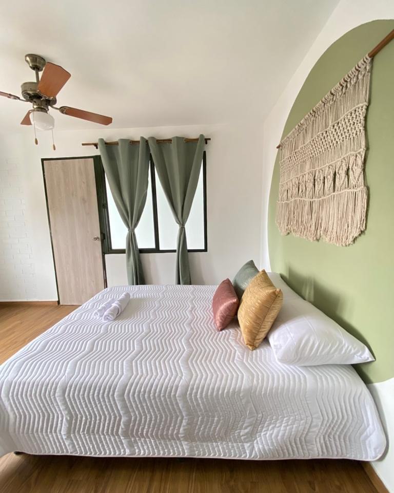 Habitación Pareja con cama doble y decoración boho en El Bohemio Hostal